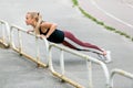 Fitness lifestyle. Young woman doing push ups in the slope. Sporty young blonde girl on a sunny day at the stadium. Healthy life Royalty Free Stock Photo