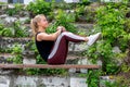 Fitness lifestyle. Young woman warming up on a bench, doing exercises on abdominal muscles. Sporty young blonde girl on a sunny Royalty Free Stock Photo