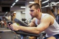 Fitness man on bicycle doing spinning at gym. Fit young man working out on gym bike. Royalty Free Stock Photo