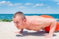 Sports. Fitness man doing push-ups on the beach Royalty Free Stock Photo