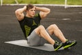 Fitness man doing sit ups in the stadium working out. Muscular male exercising abdominals, outdoor Royalty Free Stock Photo