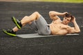 Fitness man doing sit ups in the stadium working out. Muscular male exercising abdominals, outdoor Royalty Free Stock Photo