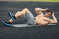 Fitness man doing sit ups in the stadium working out. Muscular male exercising abdominals, outdoor Royalty Free Stock Photo