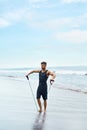 Fitness Man Exercising At Beach, Doing Expander Exercise Outdoor Royalty Free Stock Photo