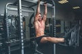 Fitness man hanging on horizontal bar performing legs raises, in the gym Royalty Free Stock Photo