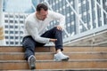 fitness man have knee pain sitting on steps of stair in the city. sport injury leg of run in urban , accident , exercise,workout Royalty Free Stock Photo