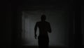 Fitness man running in dark corridor. Male jogger training in loft building Royalty Free Stock Photo