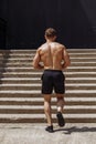 Fitness man running up the steps under a overpass