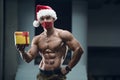 Fitness man in Santa Claus hat costume in gym