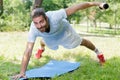 fitness man training dumbbells plank outdoors