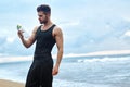 Fitness Man With Water Bottle Resting After Workout At Beach Royalty Free Stock Photo