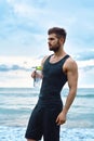 Fitness Man With Water Bottle Resting After Workout At Beach Royalty Free Stock Photo