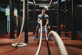 Fitness man working out with battle ropes at gym. Royalty Free Stock Photo