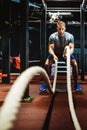 Fitness man working out with battle ropes at gym. Royalty Free Stock Photo