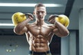 Fitness man pumping up muscles with kettlebell