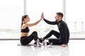 Fitness man and woman giving each other a high five after the training session in gym. Fit couple high five after workout in Royalty Free Stock Photo