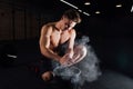 Fitness model trainer rubs his hands with chalk and talc so that fingers do not slip or slide.