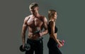 Fitness models pumping up arm with dumbbell. Couple exercising with dumbbells together. Sexy strong fit body. Couple Royalty Free Stock Photo