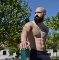 Fitness muscular man looking at the left in a public park, with a lot of space at the left side