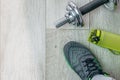 Fitness objects isolated on wooden background. Black Sneakers, dumbbells.