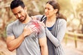Fitness, pain and injury with a woman massaging the shoulder of her boyfriend while running outdoor. Exercise, medical