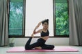 Fitness, people and healthy lifestyle concept - Woman wearing sportswear practicing mermaid asana at home for health and a firmer Royalty Free Stock Photo