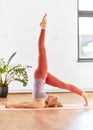 Woman doing yoga in shoulderstand at home