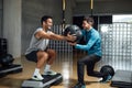 Fitness personal trainer helping man with squatting pose with medicine ball Royalty Free Stock Photo