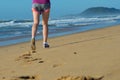 Fitness and running on beach, woman runner legs in shoes on sand near sea, healthy lifestyle and sport