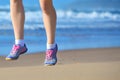 Fitness and running on beach, woman runner legs in shoes on sand near sea, healthy lifestyle and sport