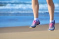 Fitness and running on beach, woman runner legs in shoes on sand near sea, healthy lifestyle and sport