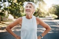 Fitness senior woman with earphones and smartwatch for her outdoor exercise, listening to music or motivation podcast Royalty Free Stock Photo