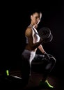 Fitness girl with dumbbells on a dark background. Athlete doing exercises in the gym Royalty Free Stock Photo