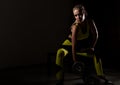 Fitness sexy girl with dumbbells on a dark background. Athlete doing exercises in the gym Royalty Free Stock Photo