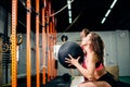 Two women throws medicine balls in fitness gym Royalty Free Stock Photo