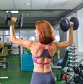 Fitness, sport, exercising lifestyle - woman with dumbbells doing exercises in gym Royalty Free Stock Photo