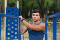 Fitness, sport, exercising, training and lifestyle concept - young man doing triceps dip on parallel bars outdoors. Royalty Free Stock Photo