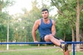 Fitness, sport, exercising, training and lifestyle concept - young man doing triceps dip on parallel bars outdoors. Royalty Free Stock Photo