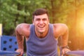 Fitness, sport, exercising, training and lifestyle concept - young man doing triceps dip on parallel bars outdoors. Royalty Free Stock Photo