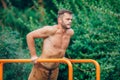 Fitness, sport, exercising, training and lifestyle concept - young man doing triceps dip on parallel bars outdoors Royalty Free Stock Photo