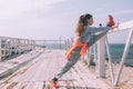 Fitness sport girl in fashion sportswear doing yoga fitness exercise in the street by sea Royalty Free Stock Photo