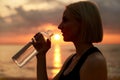 woman drinking water from bottle on beach Royalty Free Stock Photo