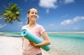 Happy smiling woman with exercise mat over beach Royalty Free Stock Photo