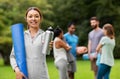 Smiling woman with yoga mat and bottle at park Royalty Free Stock Photo