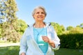 Senior woman with earphones running in summer park Royalty Free Stock Photo