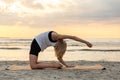 woman doing yoga camel pose on beach Royalty Free Stock Photo