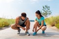 Couple of joggers tying sneakers shoelaces