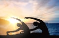 Couple doing yoga over sunset sea background Royalty Free Stock Photo