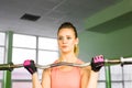 Fitness, sport, powerlifting and people concept - sporty woman exercising with barbell in gym.
