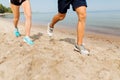 Legs of sportsmen in sneakers running along beach Royalty Free Stock Photo